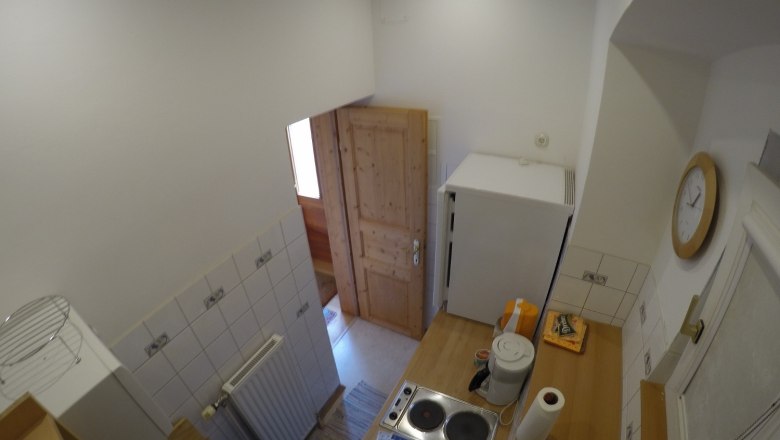 Kitchen vacation apartment 2, © dmgrauszer Small kitchen with stove, fridge and wooden door.