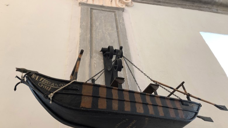 Exhibit in the Maritime Museum, © Donau Nö Tourismus/JS Model of a historic rowing boat displayed on the wall of a museum.