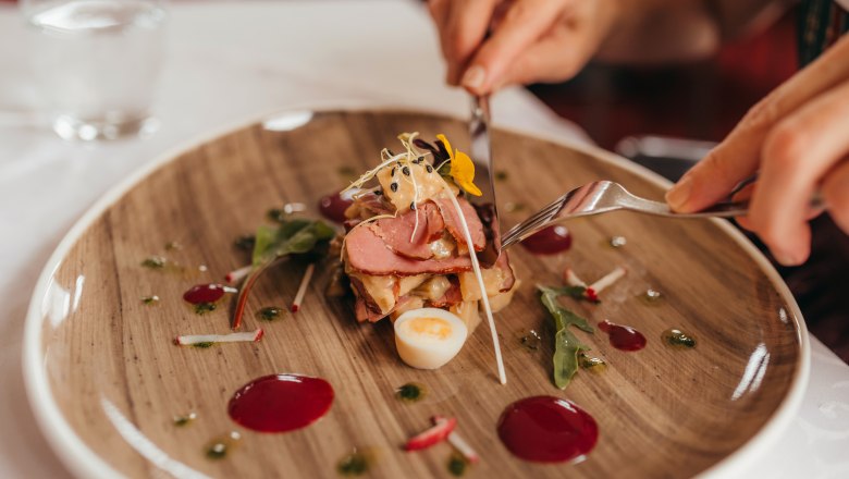 Smoked duck breast with plum and shallot chutney, © Niederösterreich Werbung/Daniela Führer A plate with smoked duck breast, plum and shallot chutney and decorations.