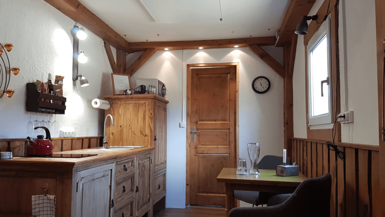 Kitchen with ceramic hob, fridge and microwave in the Tiny House Living Legends, © Edermühle Kitchen with ceramic hob, fridge and microwave in the Tiny House Living Legends, © Edermühle