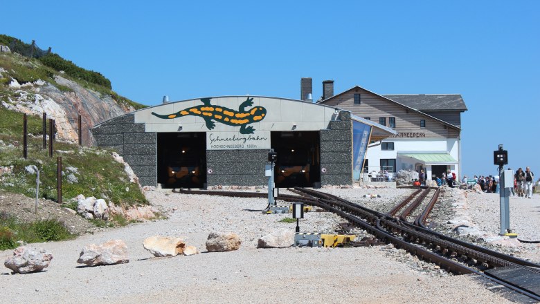 Hochschneeberg mountain lodge, © Niederösterreichische Schneebergbahn GmbH, Foto Franz Zwickl Entrance to the Schneebergbahn with Salamander logo and mountain lodge in the background.