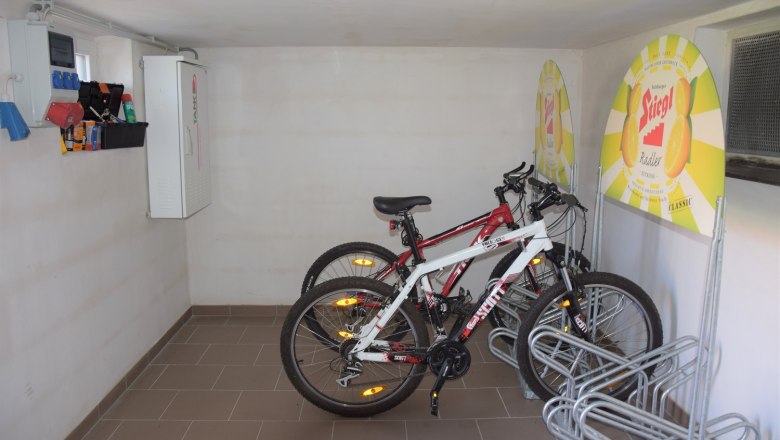 Wheel space, © Peter Pichler Bicycle room with two bicycles and advertising signs on the wall.
