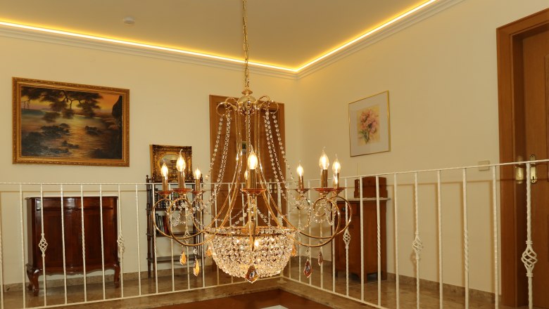 Gallery Guesthouse Punz, © Familie Punz Elegant chandelier in a stylish room with paintings and furniture.