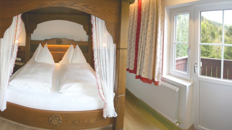 Apartment 4, © Marianne Gschaider Cozy bedroom with four-poster bed and balcony view of the forest.