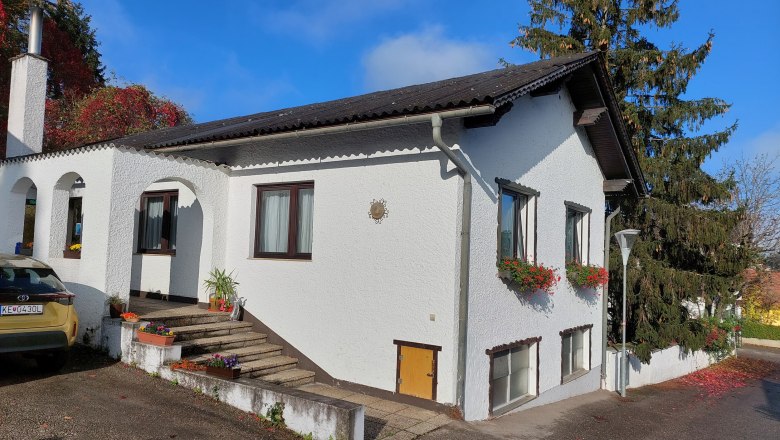 TDR-Welserhof-outside, © Nora Bartfai A white house with flowers on the windows and a car in front of it.