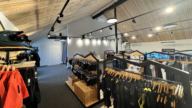 Store in the Wexl Base, © Wexl Arena St. Corona am Wechsel Interior view of a sports store with wooden ceiling and clothes on racks.
