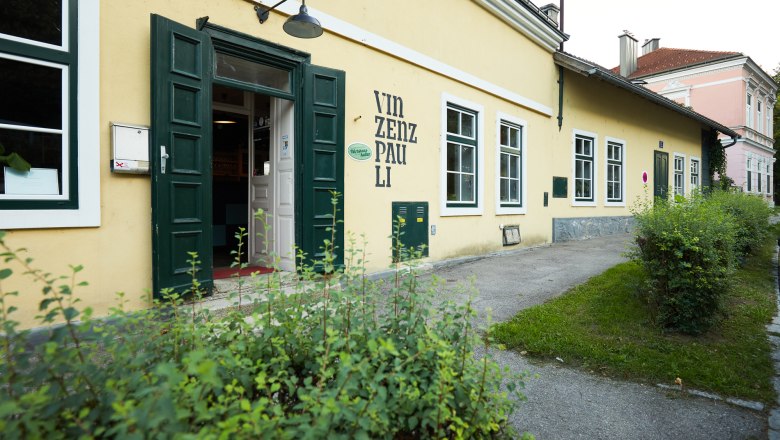 Vincent Pauli, © Niederösterreich Werbung/ Rupert Pessl Exterior view of a yellow building with the inscription 'Vinzenz Pauli'.
