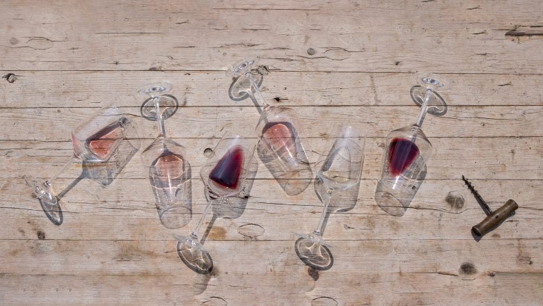 Viticulture Leidler, © Weinviertel Tourismus / Doris Schwarz-König_klein Overturned wine glasses with red wine on a wooden table.