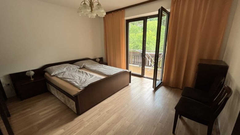 Vacation apartment by the river, © Roland Krätzel Bedroom with double bed, balcony and curtains.