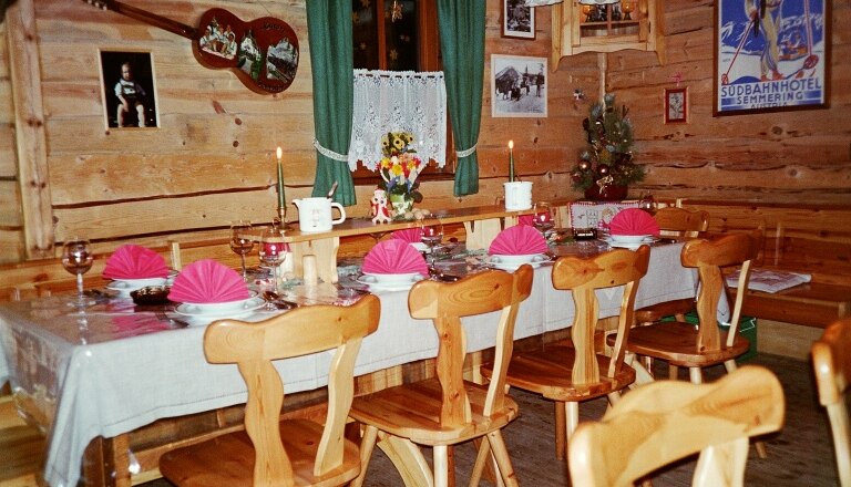 Grenzland hut, © Grenzlandhütte, Foto Paul Laschitz Cozy wooden hut with table setting, candles, decorations and pictures on the walls.