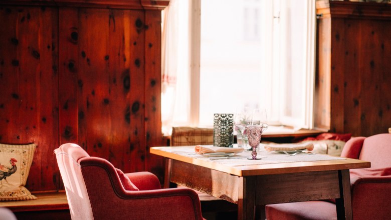 Traditional house from the 16th century, © Niederösterreich Werbung/Julius Hirtzberger Cozy furnishings with wooden walls and red armchairs.