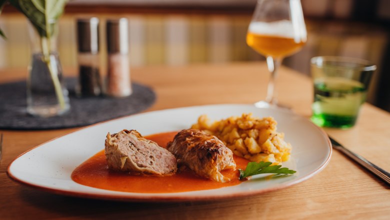 Cabbage rolls, © Niederösterreich Werbung/Daniela Führer Cabbage roulade with sauce and potato garnish served on a plate.