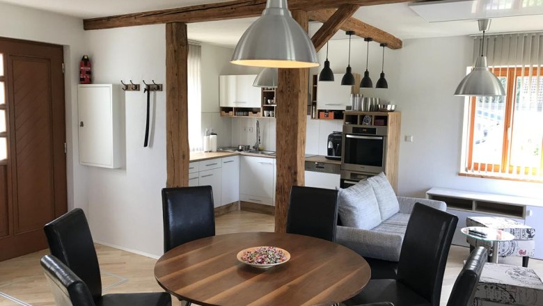 Living area, © Familie Mokesch Modern living area with dining table, chairs, kitchen and sofa.