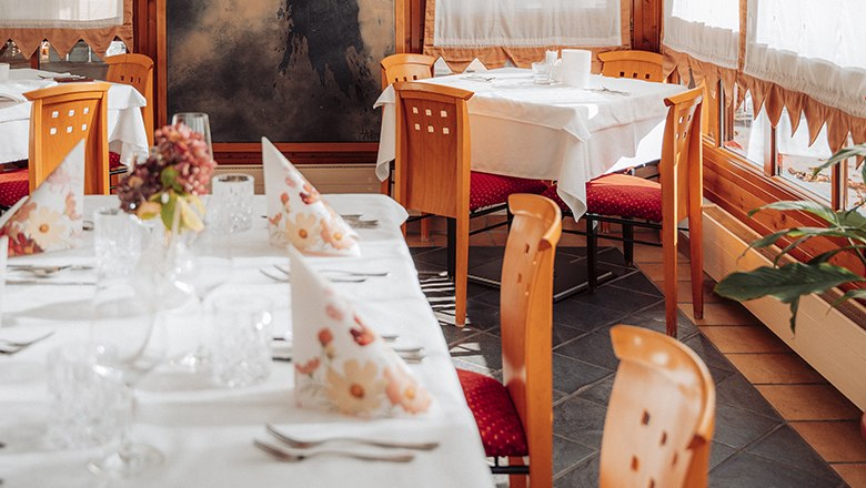 Payerbacherhof, © Payerbacherhof - Christopher Tarkus Elegant restaurant with laid tables, wooden chairs and decorative napkins.