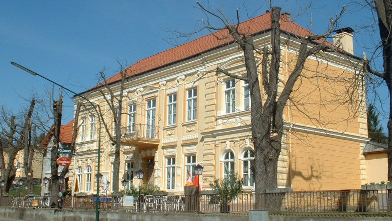 Poldiwirt Inn, © Gasthof Poldiwirt Yellow building with a red roof and bare trees in front of it.