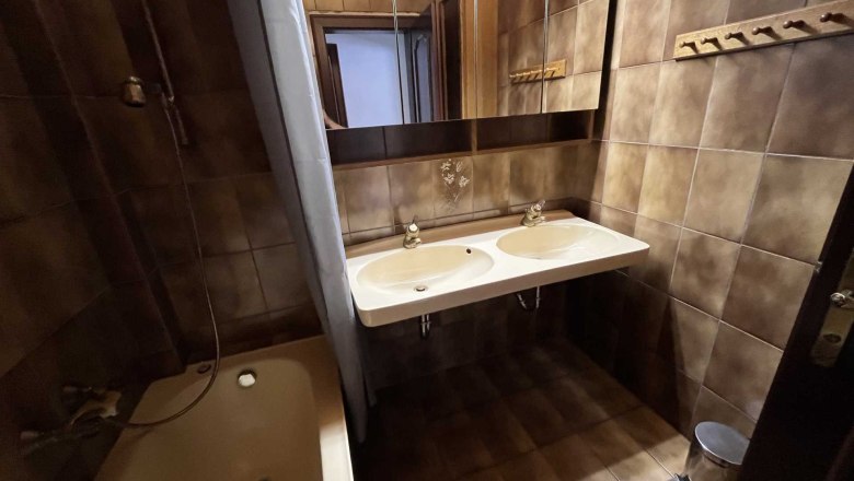 Vacation apartment by the river, © Roland Krätzel Bathroom with brown tiles, double washbasin, bathtub and mirror.