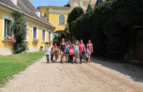 Paradise for children, teenagers and adults, © rgf Group of children and adults with pony in front of yellow building.