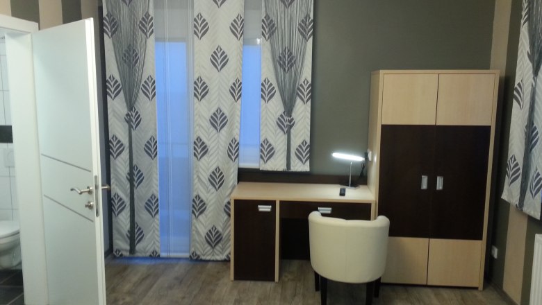 Spacious twin room, © Konrad Brandl A modern hotel room with desk, chair and closet.