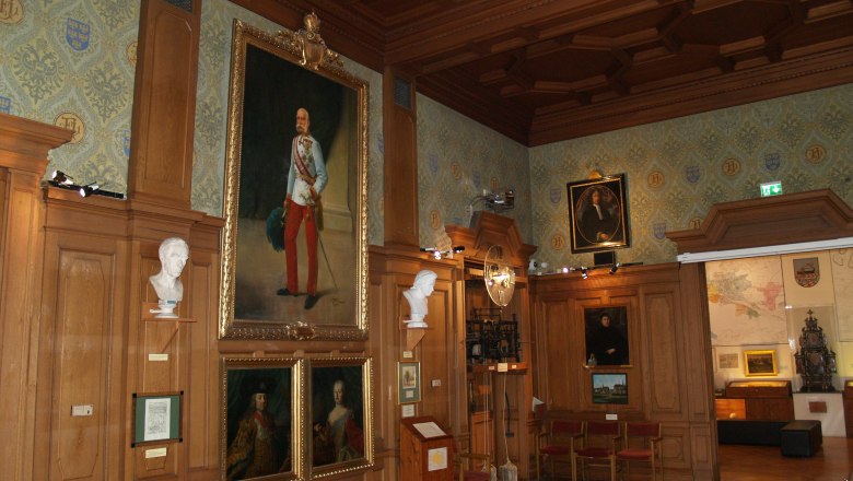 Great Hall, © Rollettmuseum A historic hall with wood paneling, paintings and busts on the walls.