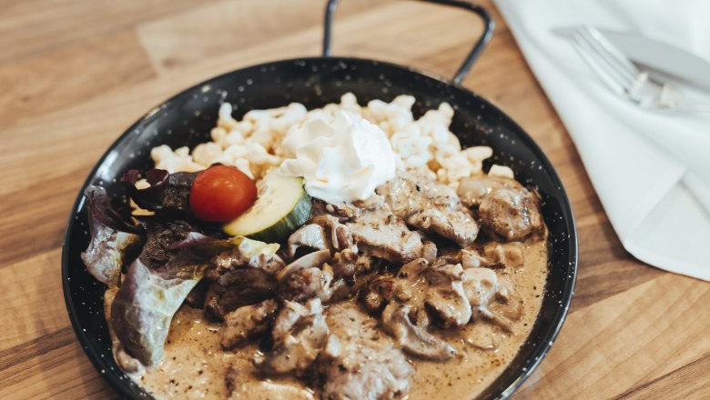 Specialty of the house: Echsi Pfandl, © Niederösterreich Werbung/David Schreiber A dish in a pan with meat, spaetzle, cream and vegetables.