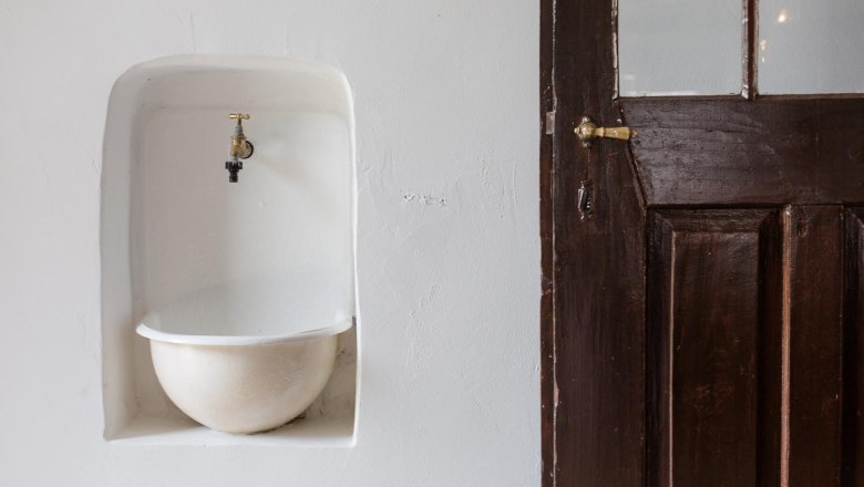 Klinger's guest house, © Astrid Bartl An old tap over a sunken basin next to a wooden door.