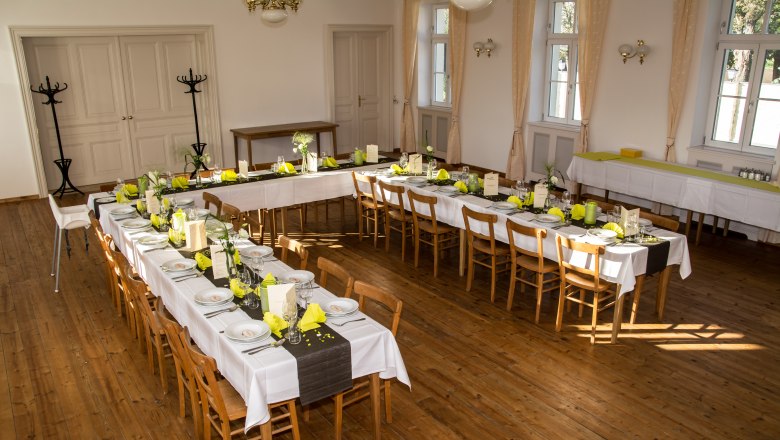 Event hall in the Weydner Wirtshaus, © Weydner Wirtshaus Festively decorated event hall with long tables and yellow napkins.