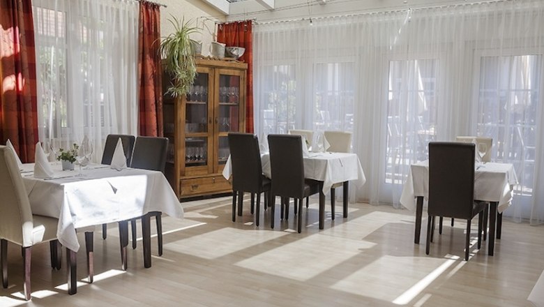 Königsbrunner Landgasthof Mann, © Simon Jappel Interior view of a bright restaurant with set tables and chairs.