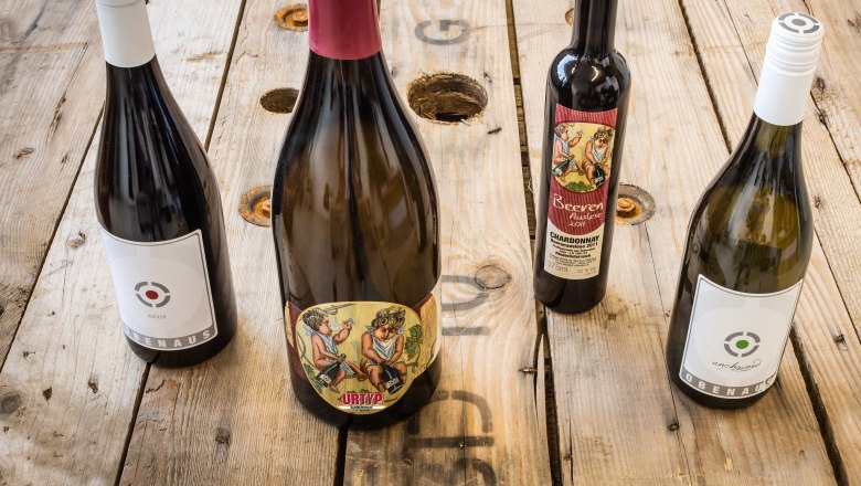 Wine specialties, © Martin Obenaus Four bottles of wine on a wooden table.