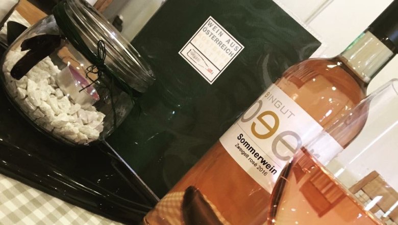 Rosé, © Weingut Peer A bottle of rosé wine and a filled wine glass on a table with decoration.