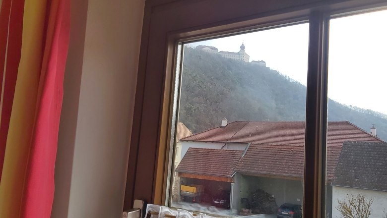 View from the window, © Familie Hofbauer View from a window of a building on a hill and houses with red roofs in the foreground.