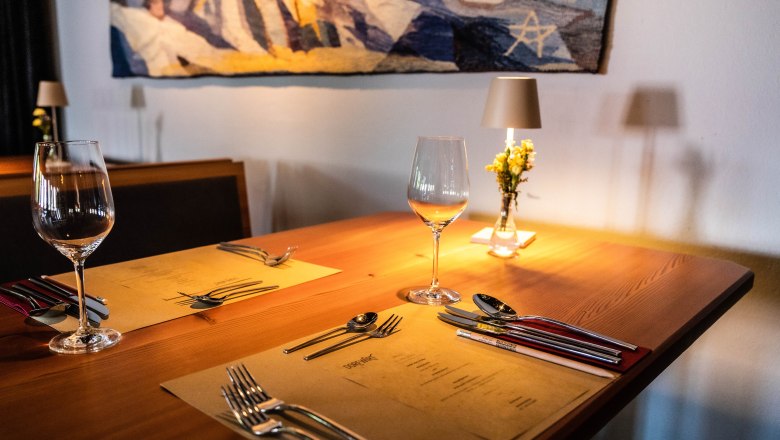 Stylish interior in the restaurant, © Pamela Schmatz Elegant table in a restaurant with wine glasses, cutlery and flowers.