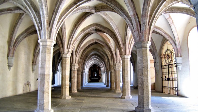Dormitory, © Stift Heiligenkreuz A medieval cloister with Gothic vaults and stone columns.