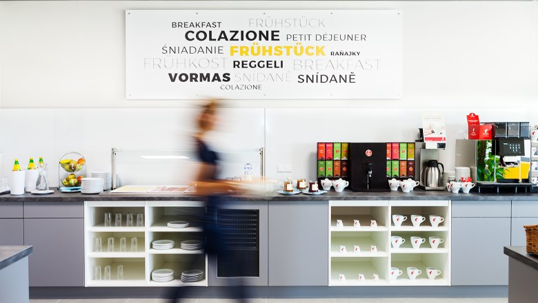 Breakfast, © Hotel Tullnerfeld A long gray counter with cups and crockery. Everything for coffee and tea is on the counter.