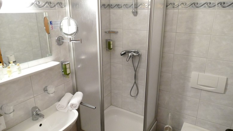 Pool at night, © Besta Betriebs GmbH Bathroom with shower, washbasin and mirror.