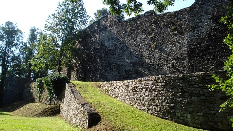 Along the city wall, © C. Wardell Old city wall with green area and trees in the sunlight.
