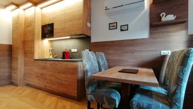 Apartment with kitchen in the Goldener Stern, © Inhaber Peter Mayer Modern kitchen with wooden furniture and dining table in an apartment.