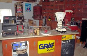Museum for village culture in Grossengersdorf, © Museum für Dorfkultur in Grossengersdorf Interior view of a historic village store with scales, cash register and old advertising signs.