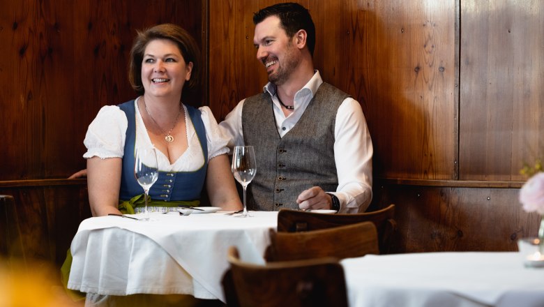 Thomas and Nicola Hopfeld, © Niederösterreich Werbung/Martina Siebenhandl Smiling couple in traditional dress in a restaurant.