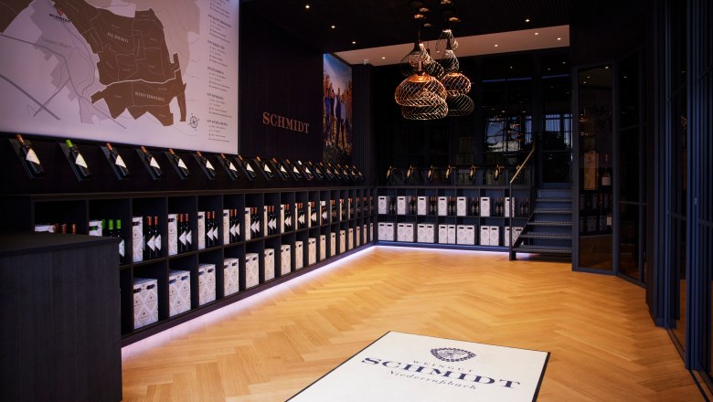 Self-service store, © Ben Leitern Interior view of a modern wine store with wooden floor, wine bottles on shelves and a large wall map.