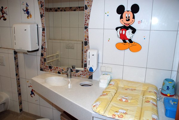 Zum grünen Baum Gasthof Schreiblehner, © Gasthof zum grünen Baum Schreiblehner Child-friendly bathroom with Mickey Mouse decor and changing table.