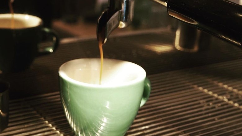 Cappuccino, © Sabathiel Espresso machine fills a green cup with coffee.
