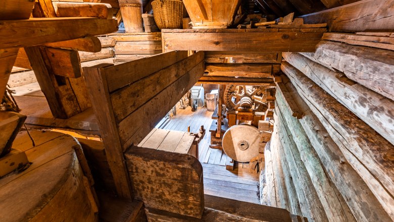 Krumbach Museum Village, © Wiener Alpen, Christian Kremsl Interior view of an old mill with wooden structures and millstone.