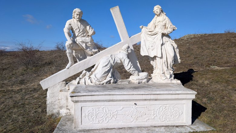 Calvary, © Retzer Land / Daniel Wöhrer Stone sculpture of a religious scene with three figures and a cross on a hill.