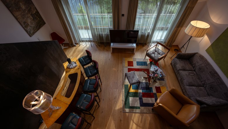 At the Park Hotel, © Niederösterreich Werbung / Maximilian Pawlikowsky Living room with modern furnishings, colorful carpet and large windows.