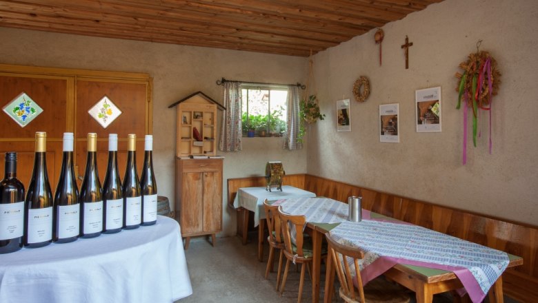 Tasting room at the Piewald winery, © Fr. Löff Tasting room at the Piewald winery with wine bottles on a table and rustic furnishings.