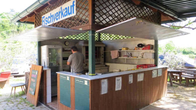 Fish sale, © Urani A small outdoor fish stall with a man working inside.