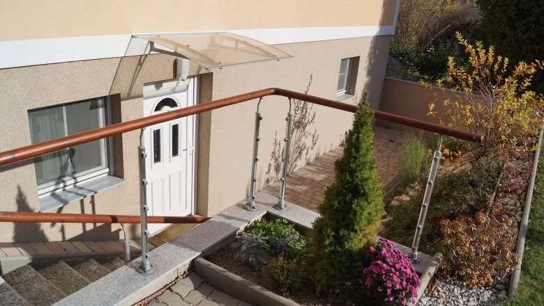 Entrance area, © Stern Entrance area of a house with white door, railing and garden.