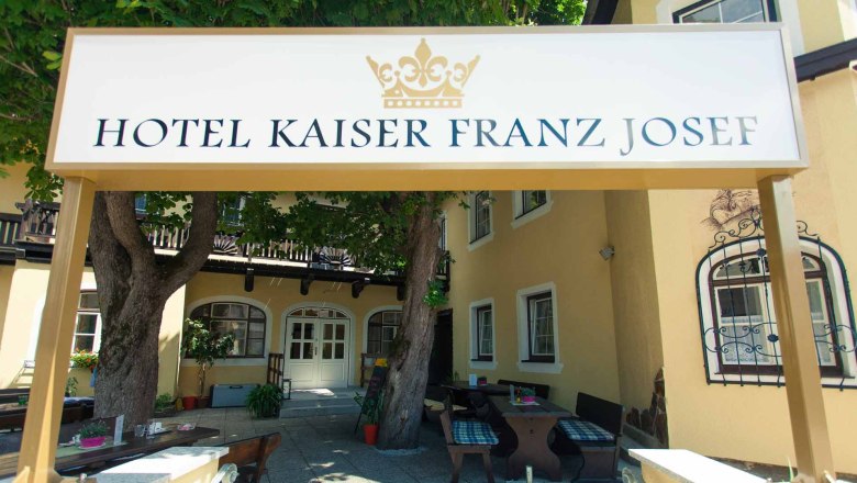 Garden Hotel Kaiser Franz Josef, © Hotel Kaiser Franz Josef Entrance to the Hotel Kaiser Franz Josef with sign and trees.