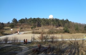 Bush hill, © Gemeinde Gnadendorf Landscape with hills, forest and radar dome under a blue sky.