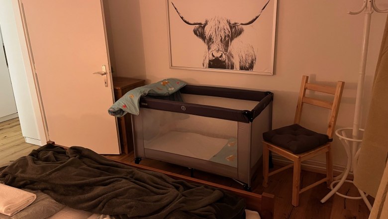 Bedroom option for a baby crib, © Anita Gallei Bedroom with crib, chair and picture of a highland cow on the wall.